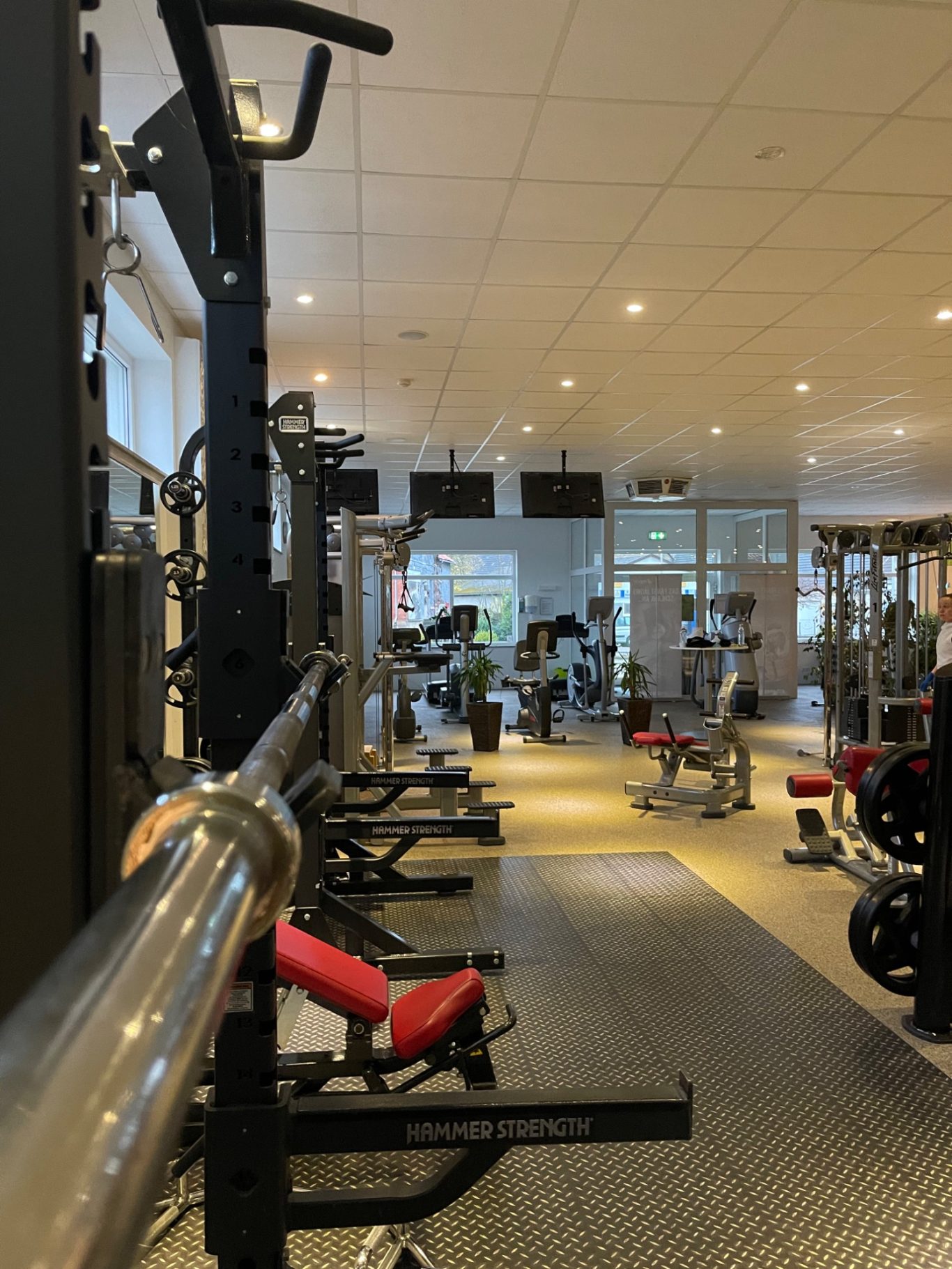 Moderne Fitnessstudio mit verschiedenen Trainingsgeräten und Platz zum Workout.