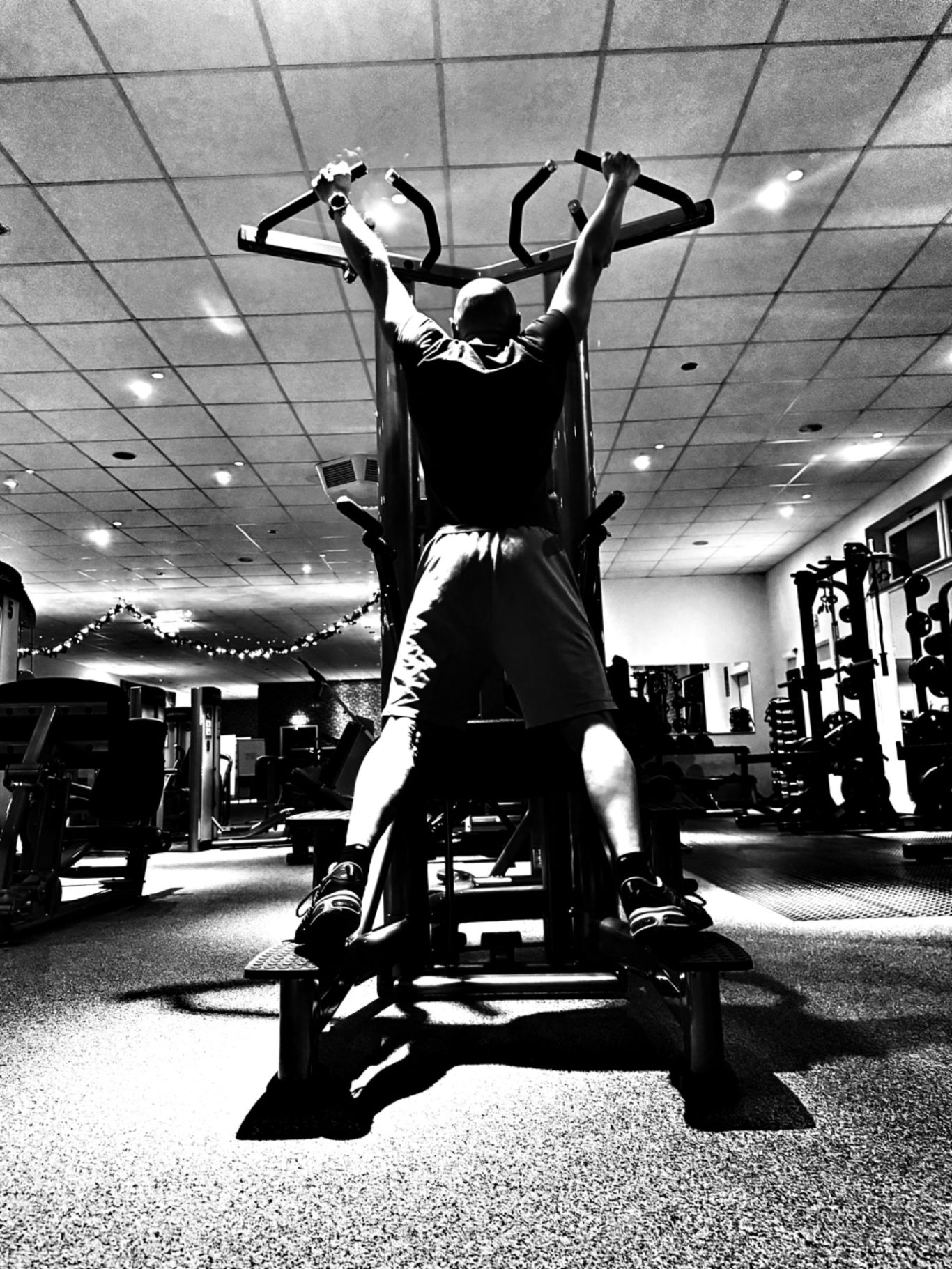 Mann macht Klimmzüge von hinten aufgenommen