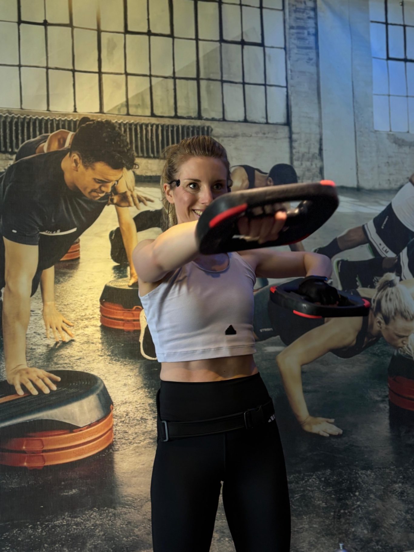 Frau beim Workout mit einer Gewichtsscheibe.
